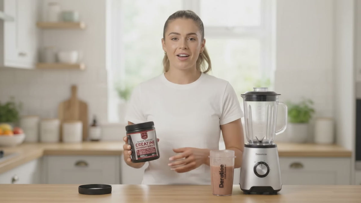 Woman in a kitchen holding Drs Diet Creatine Monohydrate and a blended protein shake